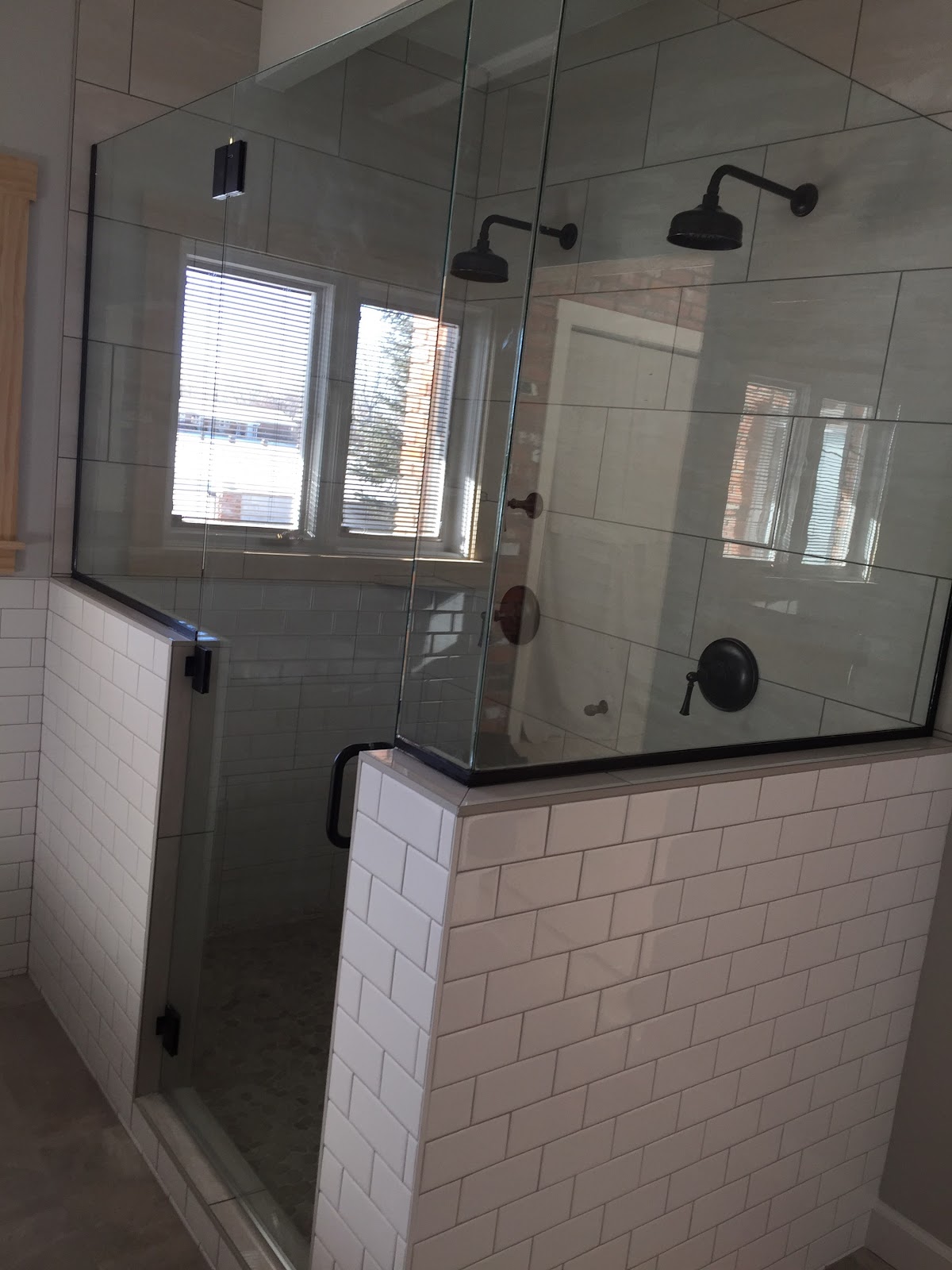 Finished glass walk-in shower with tiled half wall